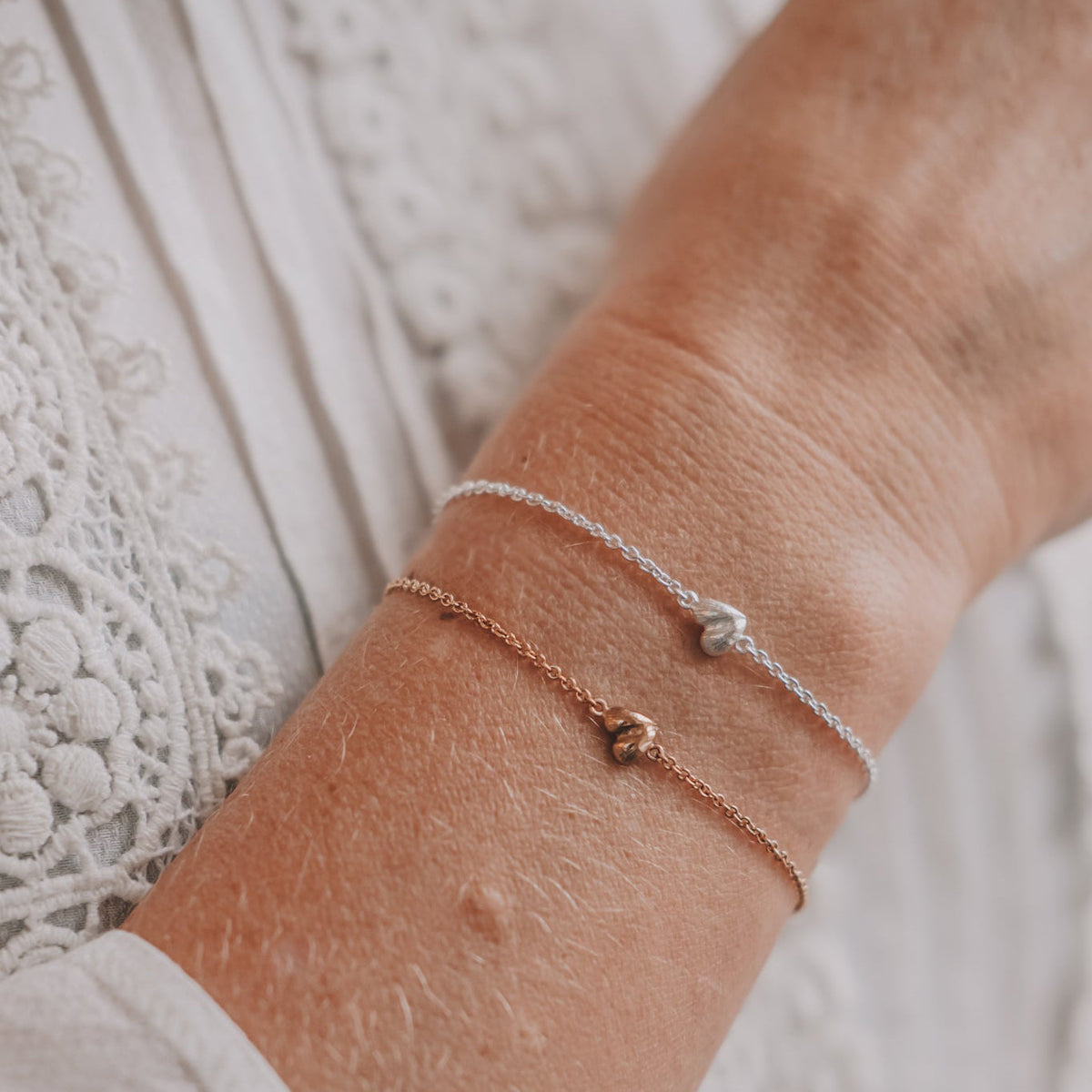 Armband i silver och guld med tunna kedjor och små hjärtan, ett fint sätt att blanda guld och silver.