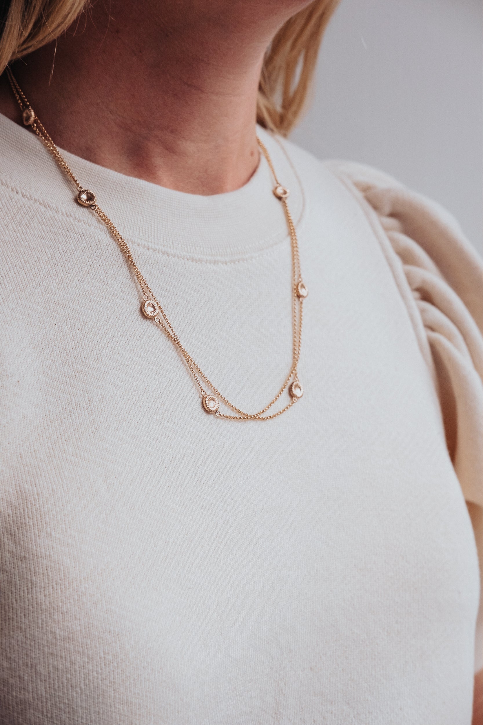 Kort roséguldhalsband med knappkorall på kvinna