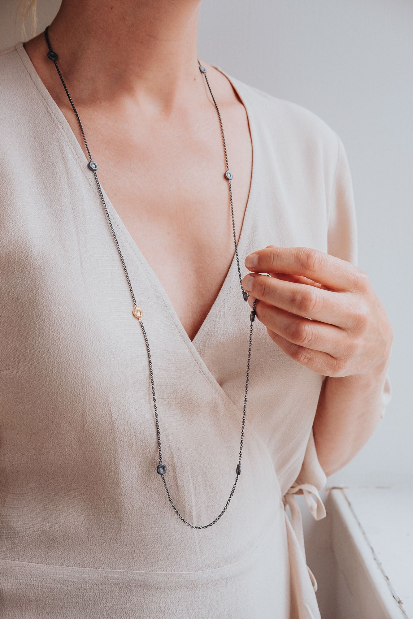 Långt svart knappkorallhalsband på kvinna