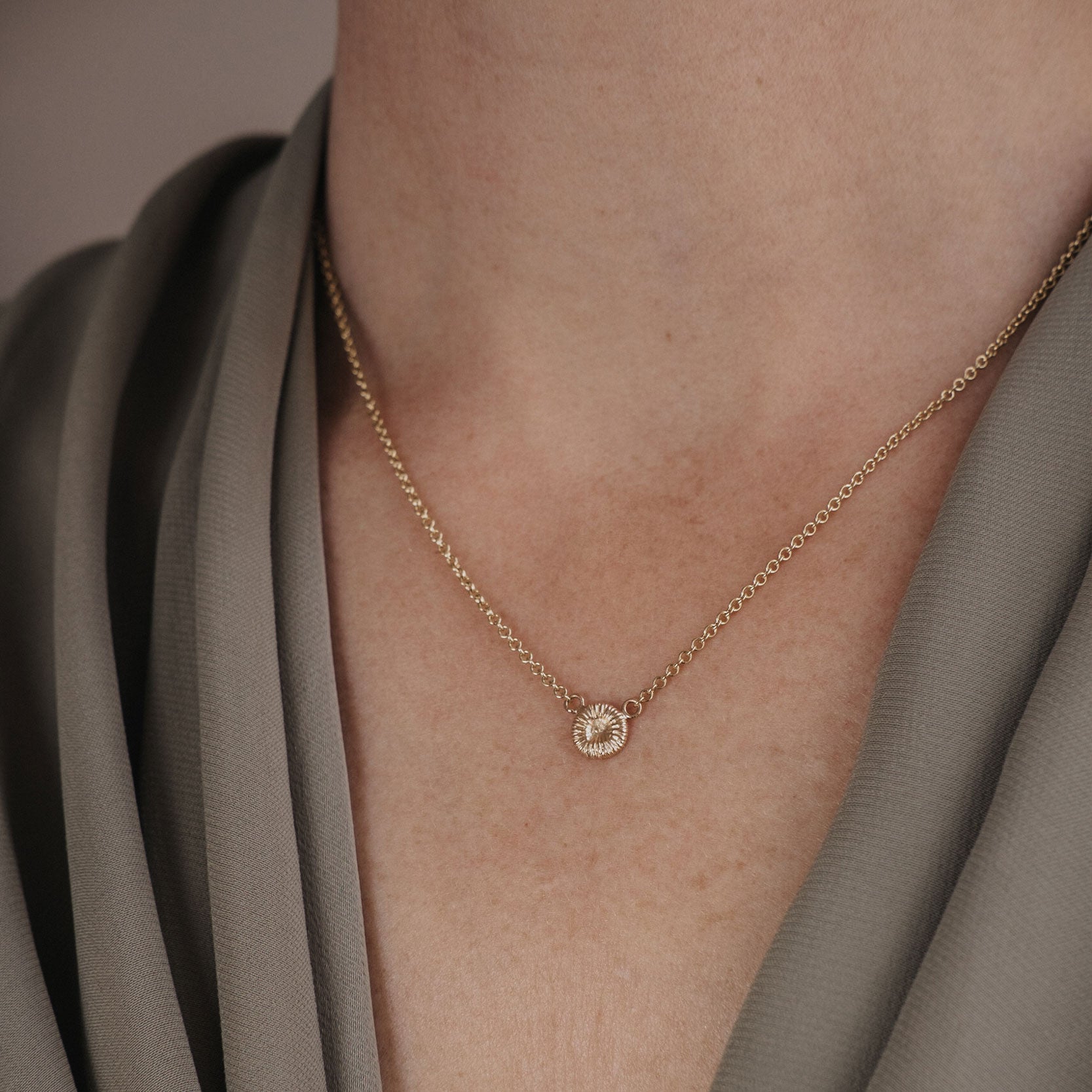 Knappkorall halsband i guld på modell