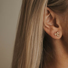 Knappkorall örhängen i guld på örat