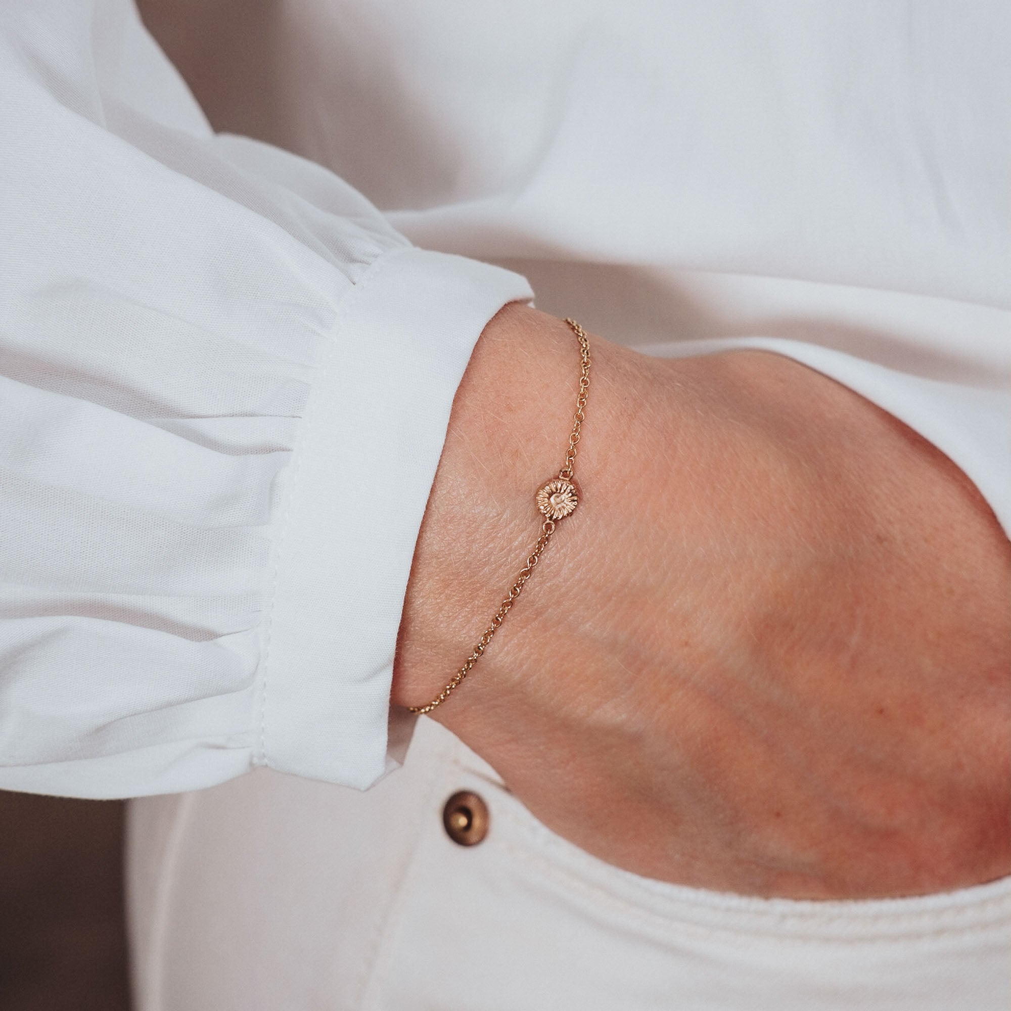 Knappkorall armband i guld på hand