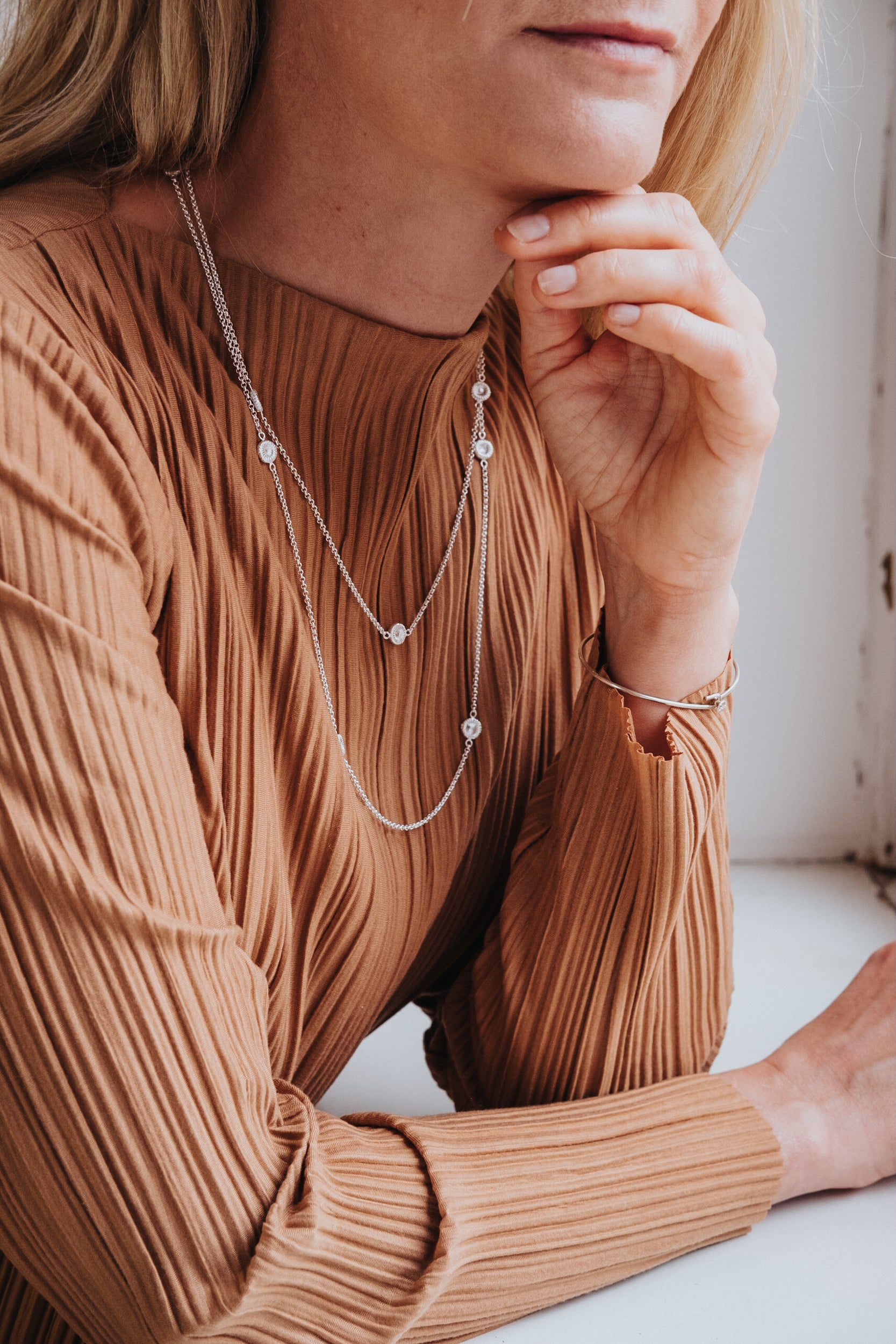 Kort knappkorallhalsband på kvinna i brun klänning