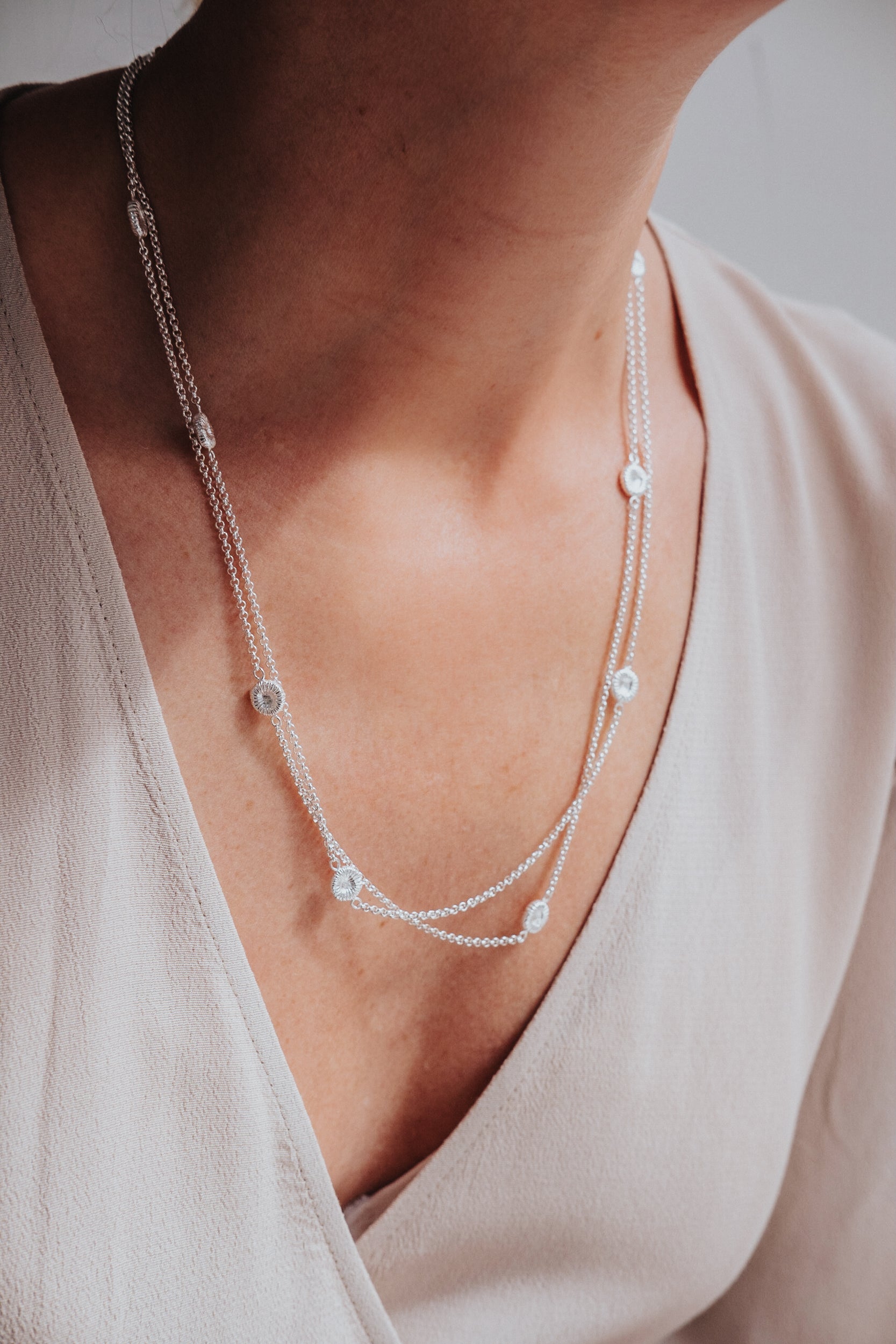 Kort halsband med knappkorall på kvinna i beige klänning