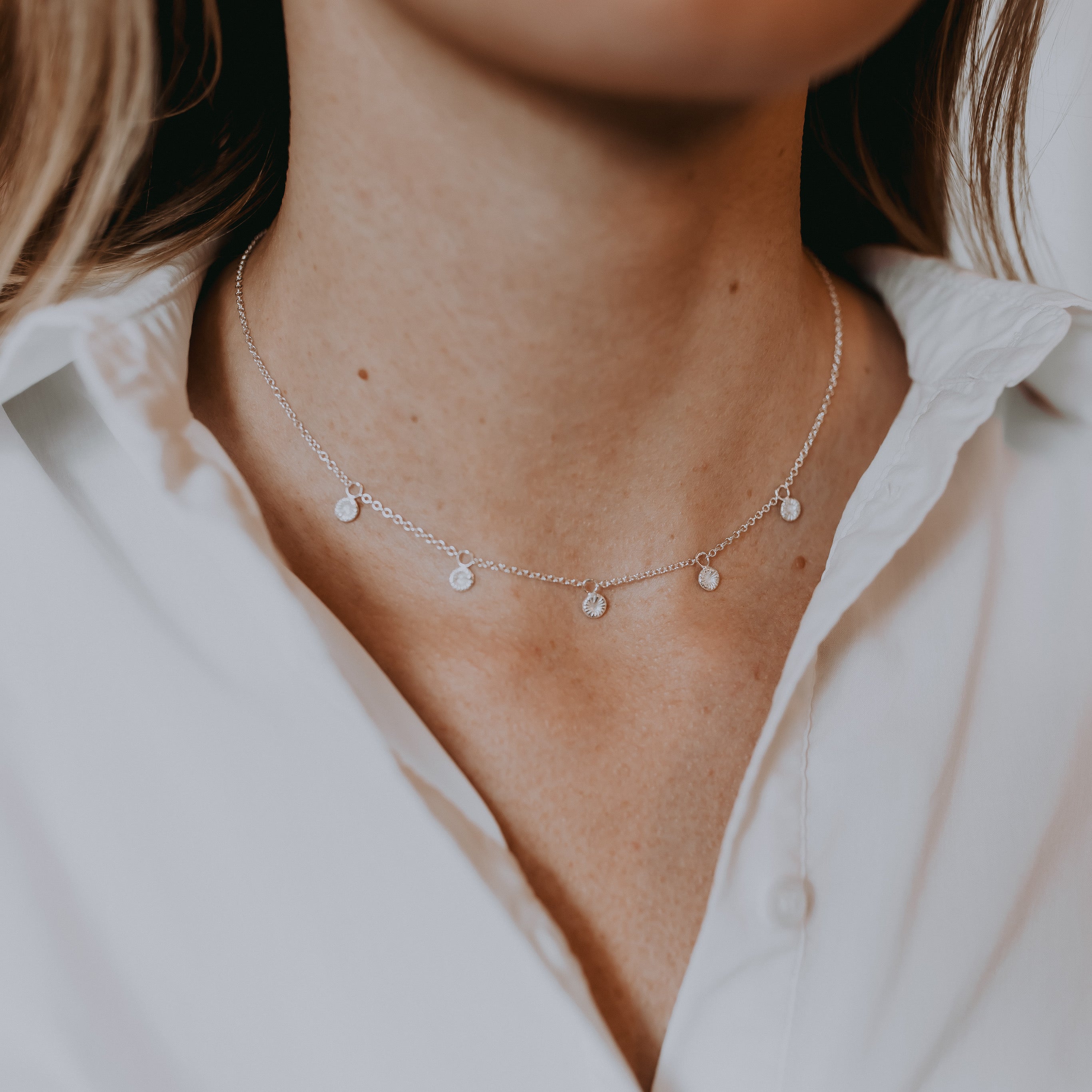 Silverhalsband med fem små droppar.